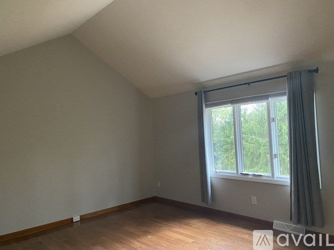 A room with a window and a wooden floor.