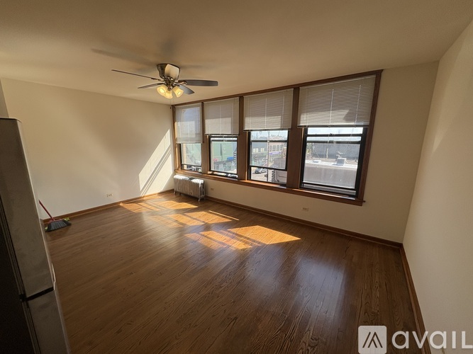 A room with wooden flooring and a ceiling fan.