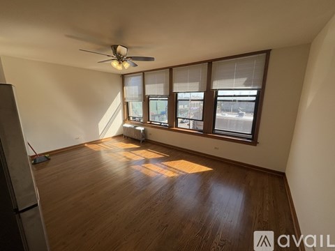 A room with wooden flooring and a ceiling fan.