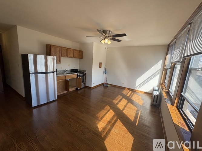 A spacious living room with a kitchen area in the background.