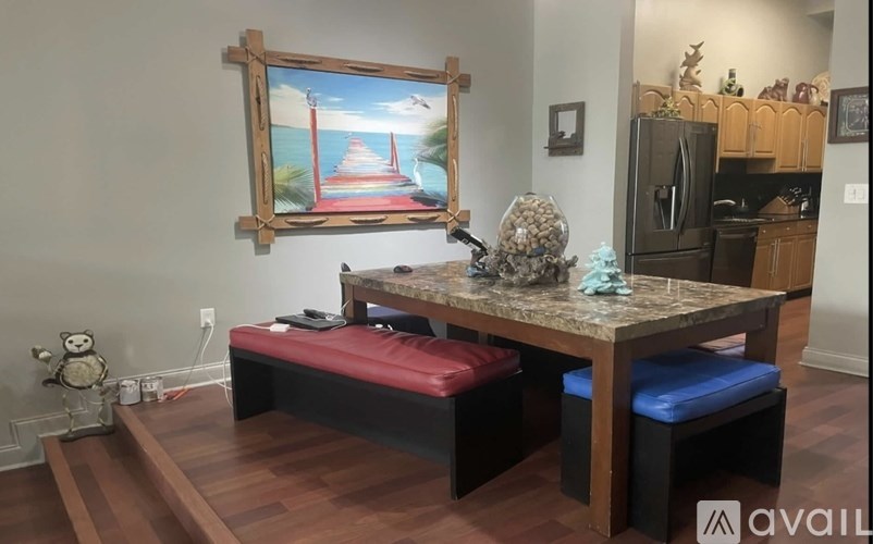 A room with a table, bench, and a painting on the wall.