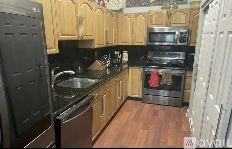 A kitchen with wooden cabinets and black appliances.