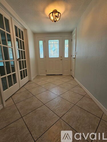 A hallway with tiled floors and a light fixture on the ceiling.