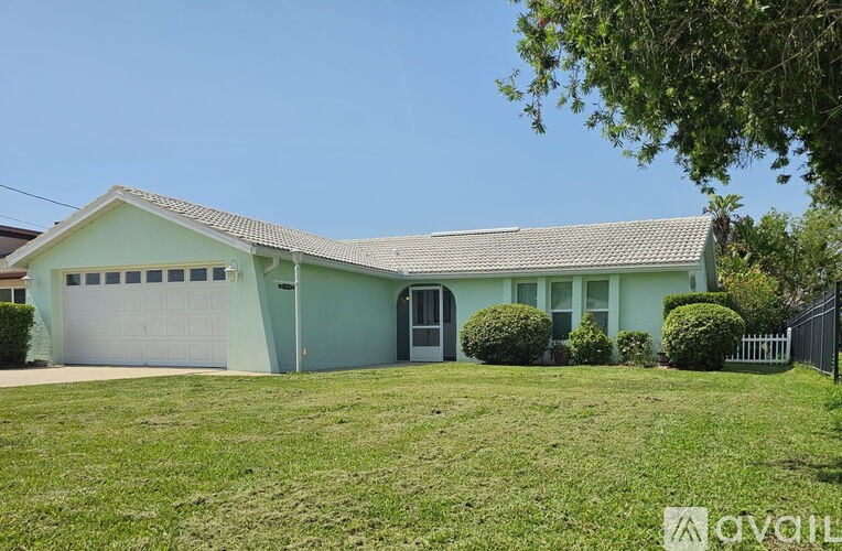 A house with a green roof and a white garage door is for sale.