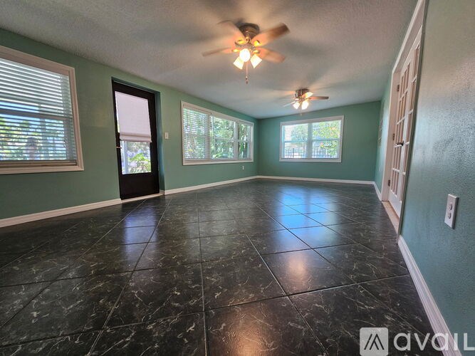 A room with a ceiling fan and tile flooring.