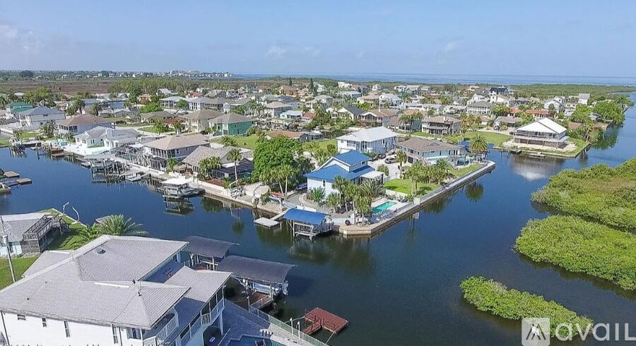 A bird's eye view of a waterfront community with houses and boats.