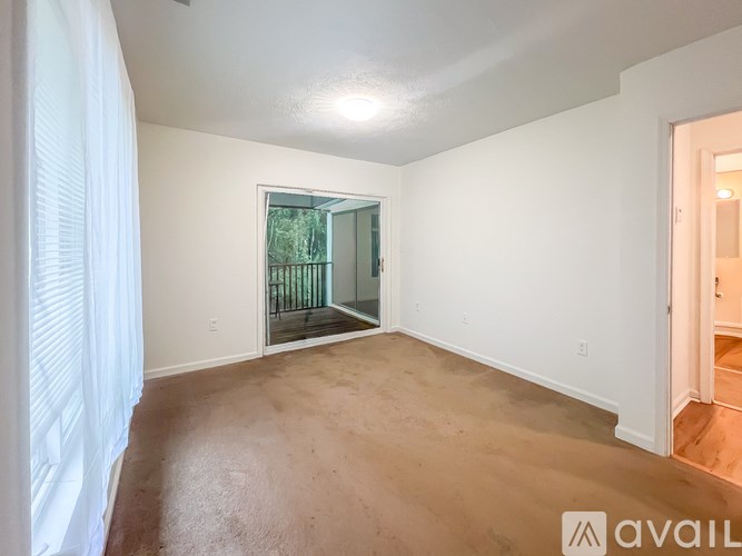 A room with a sliding glass door leading to a balcony.