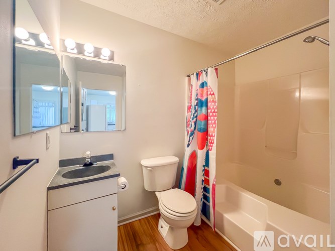 A bathroom with a toilet, sink, and shower.