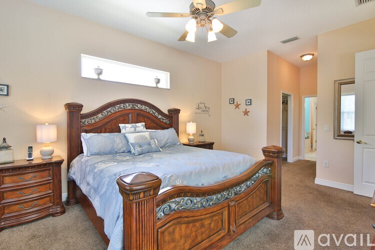 A bedroom with a large bed and a ceiling fan.