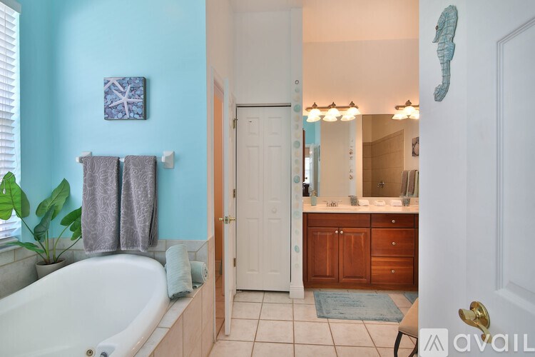 A bathroom with a blue wall and a white bathtub.
