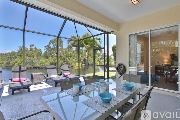 A glass table with chairs and a view of the outdoors.
