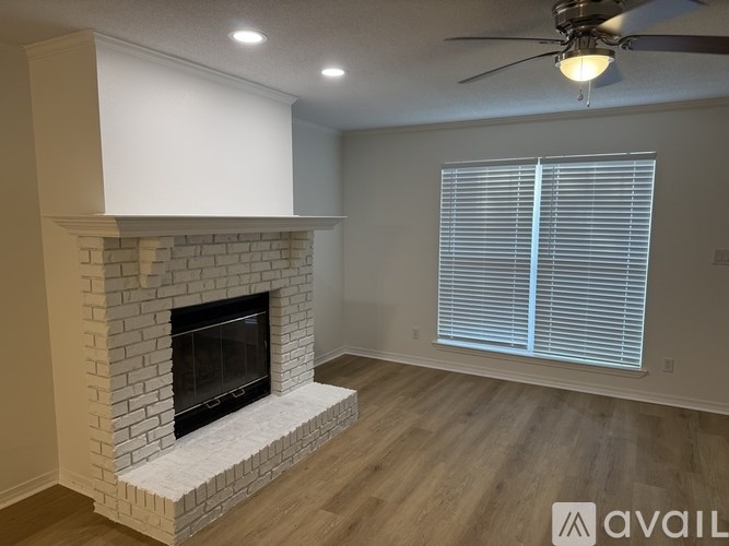 A living room with a fireplace and a ceiling fan.