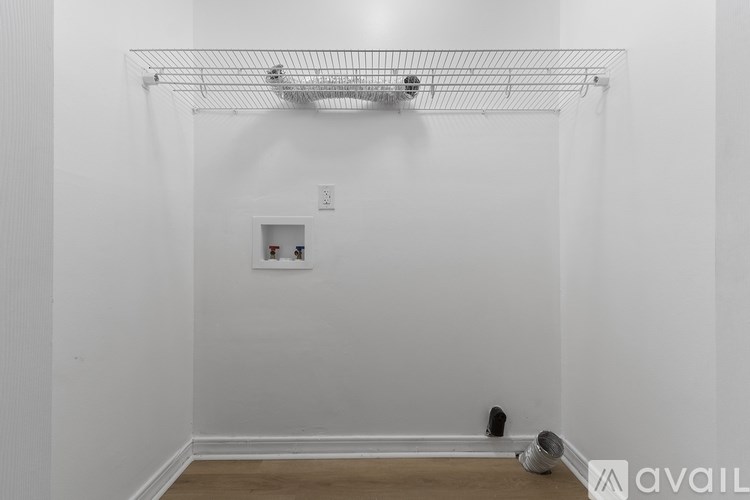 A white wall with a shelf and a light switch.