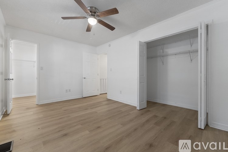 A room with a ceiling fan and wooden flooring.