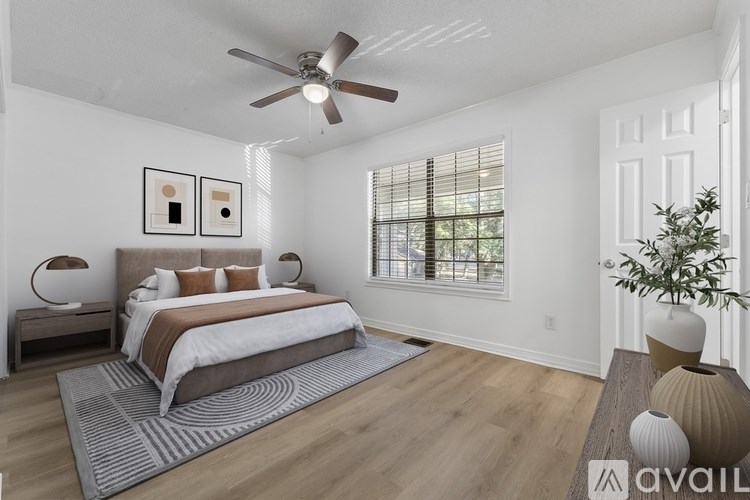 A bedroom with a large bed and a ceiling fan.