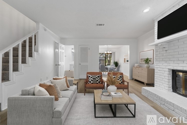 A living room with a grey couch, a coffee table, and a fireplace.