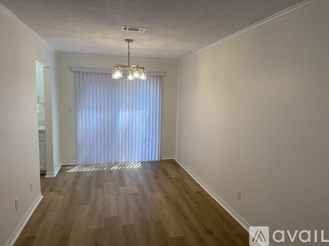 A room with wooden flooring and a chandelier.