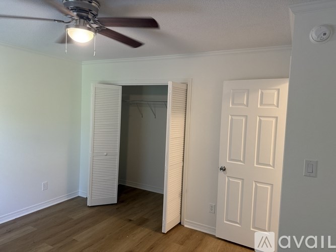 A room with a ceiling fan and a door.