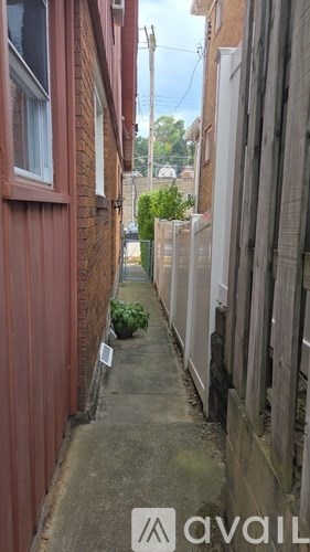 A narrow alley with a sign that says "available" on the bottom.