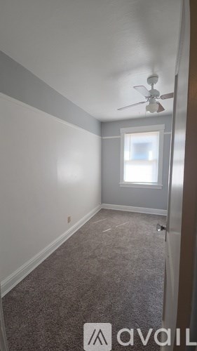 A room with a fan and a window.