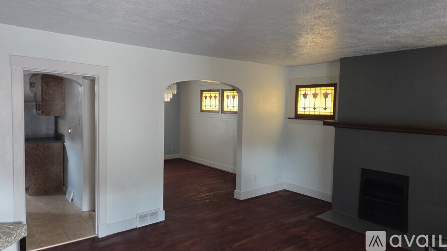 A room with a fireplace and two windows.