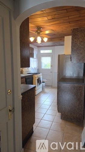 A kitchen with a refrigerator, sink, and cabinets.
