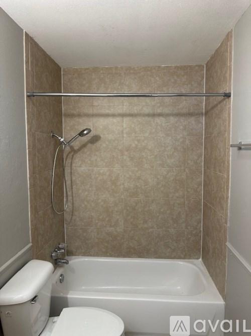 A bathroom with a toilet, tub, and shower.