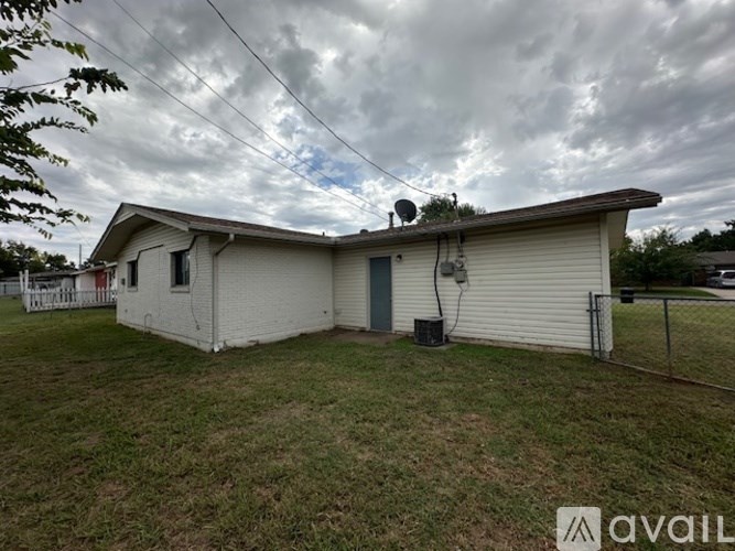 A house with a grey roof and a white fence.