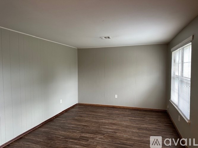 A room with wooden flooring and white walls.