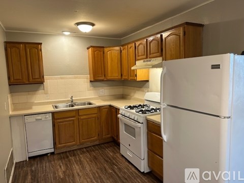A kitchen with wooden cabinets and white appliances.