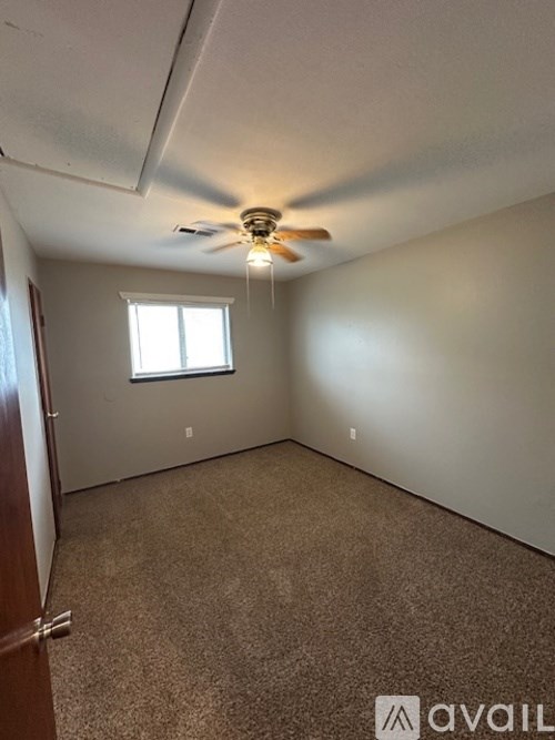 A room with a ceiling fan and a window.