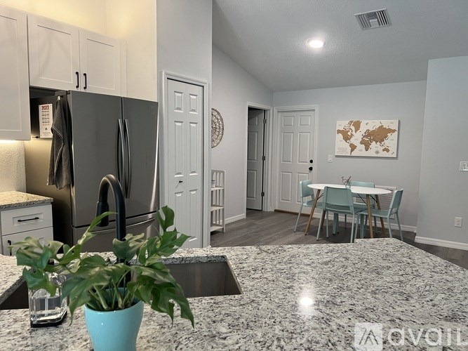 A kitchen with a granite countertop and a potted plant on it.