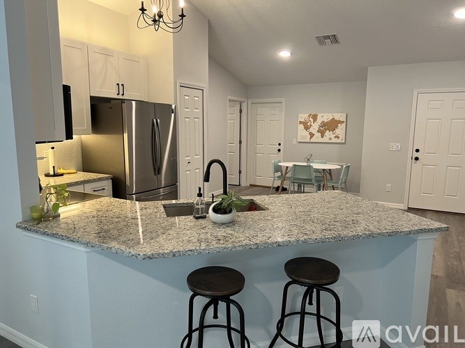 A kitchen with granite countertops and a refrigerator.