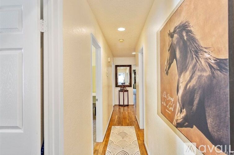A hallway with a horse painting on the wall.