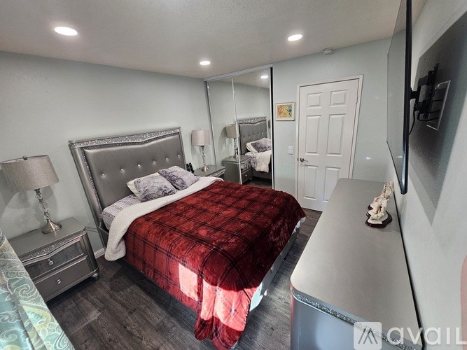 A bedroom with a bed, nightstand, and a mirror.