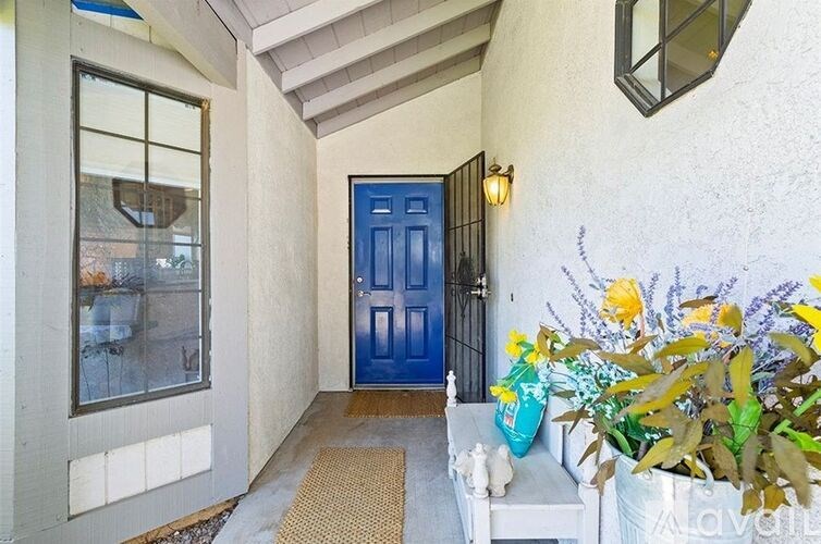 A blue door is on the right side of a white wall.