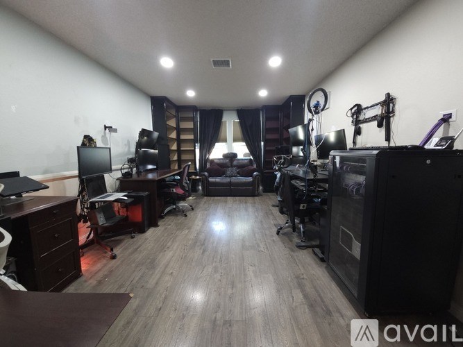 A room with a desk, computer, and other equipment.