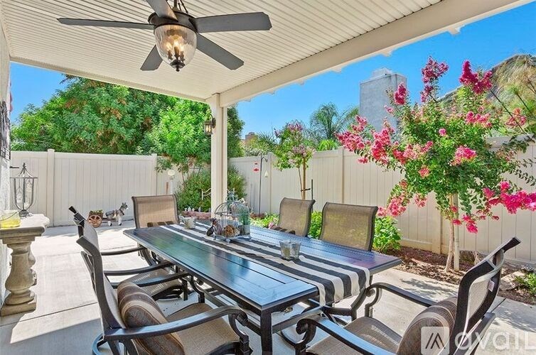 A patio with a table and chairs is covered by a roof.