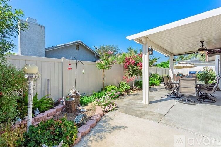 A backyard with a patio and a fence.