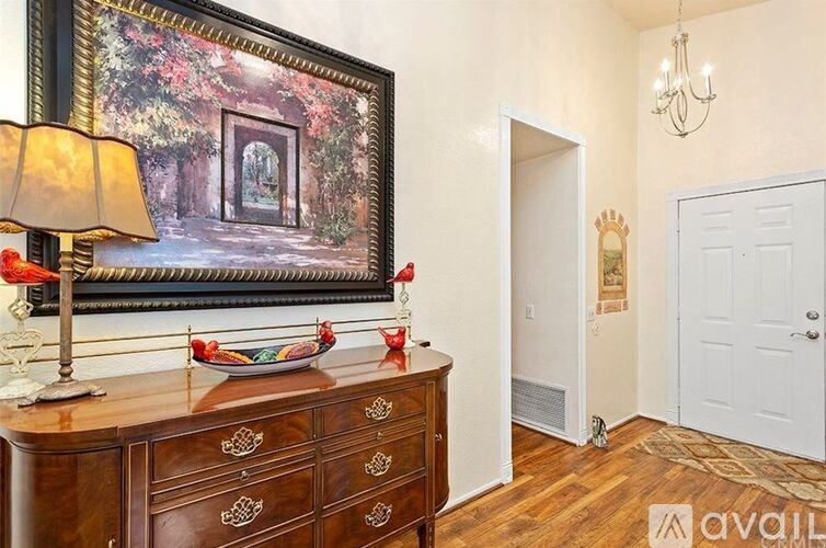 A room with a wooden dresser and a painting on the wall.