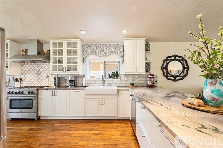 A kitchen with white cabinets and a wooden counter top.