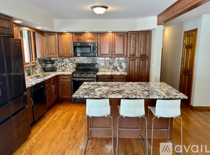 A kitchen with a table and chairs in front of it.