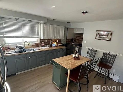 A kitchen with a table and chairs in front of it.