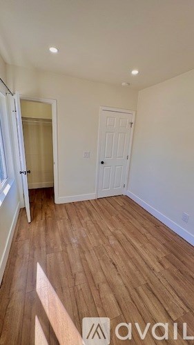 A room with wooden flooring and a white door.