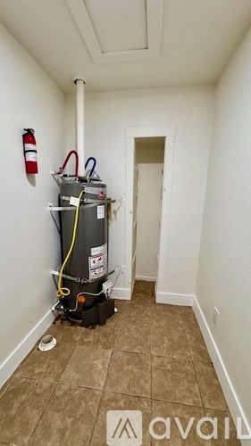 A room with a heater and a fire extinguisher on the wall.