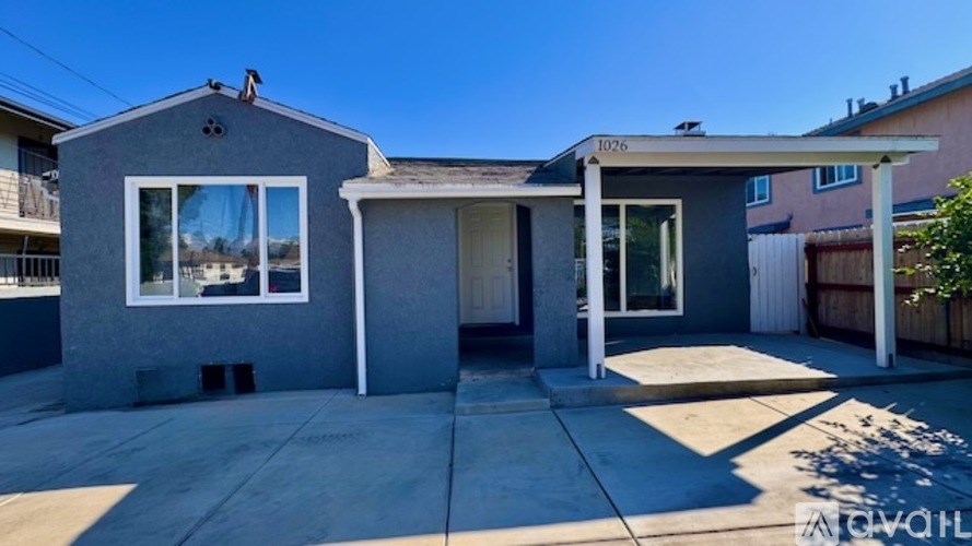 A grey house with a white door and windows.