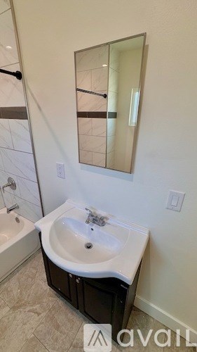 A bathroom with a sink, mirror and bathtub.