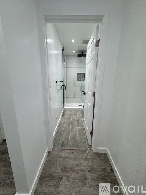 A hallway with a tiled floor and white walls.