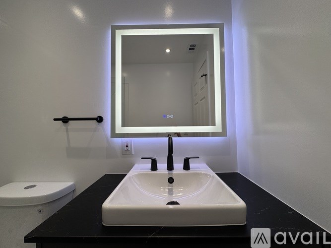 A modern bathroom with a white sink and a mirror above it.