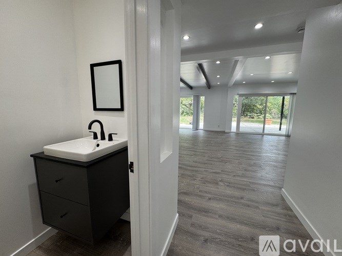 A bathroom with a sink, mirror, and cabinet.